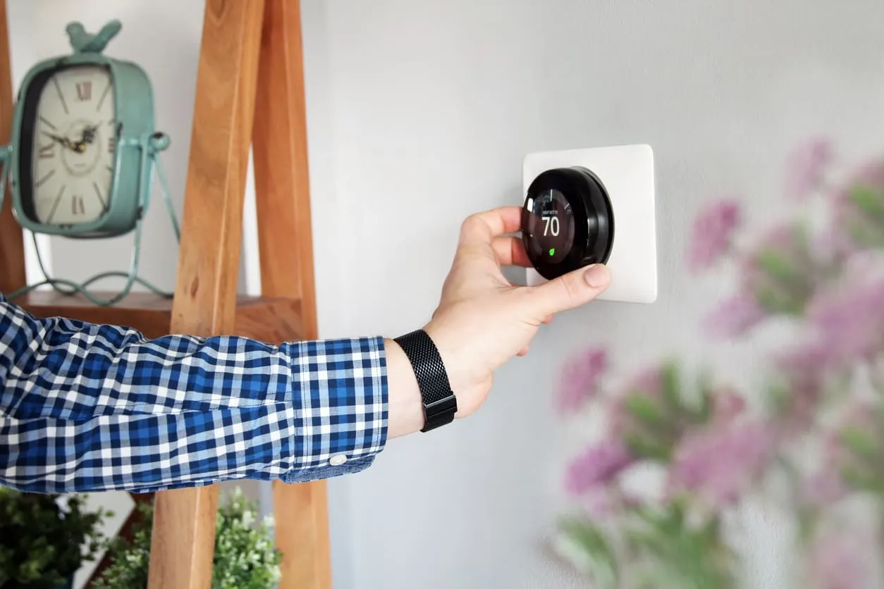 Man Turning on Smart Thermostat