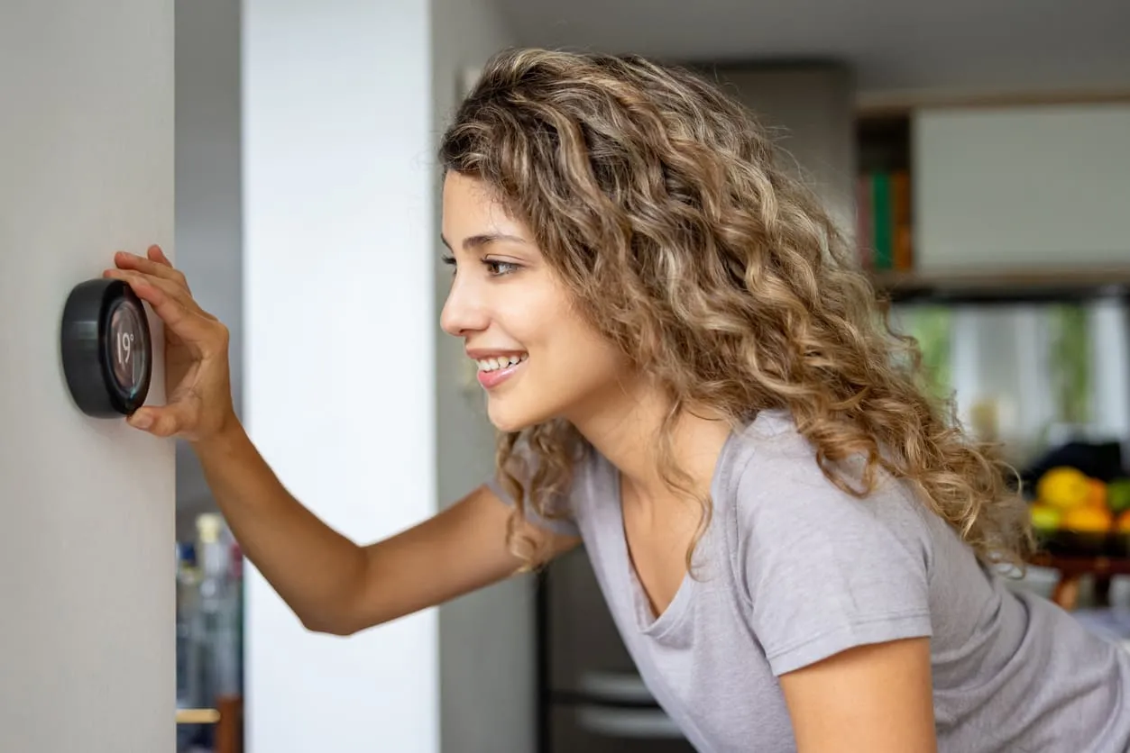 Woman Using Smart Thermostat